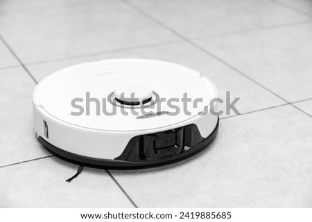 robot vacuum cleaner in modern smart home, robotic vacuum cleaner on tiles floor, Robot vacuum cleaner cleaning dust on tile floors. Modern smart cleaning technology housekeeping.	 Royalty-Free Stock Photo #2419885685