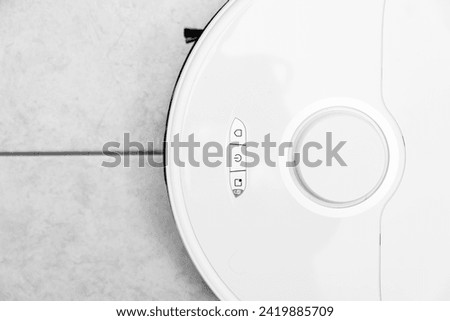 robot vacuum cleaner in modern smart home, robotic vacuum cleaner on tiles floor, Robot vacuum cleaner cleaning dust on tile floors. Modern smart cleaning technology housekeeping.	 Royalty-Free Stock Photo #2419885709