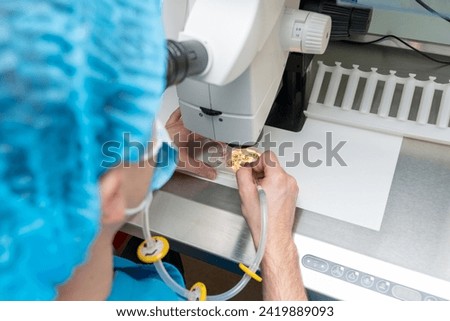 Embriologist putting sperm sample to examine under microscope or collecting in vitro cultured embryos for biopsy. Reproductive medicine clinic. Artificial insemination. Artificial conception clinic. Royalty-Free Stock Photo #2419889093