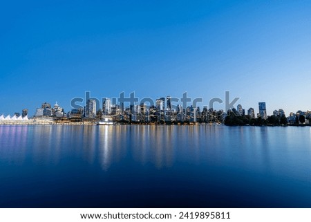 A wide-angle long exposure blue hour photo of the Vancouver skyline and Vancouver Harbour from Stanley Park.