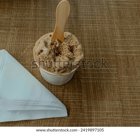 Paper cup with tasty chocolate ice cream with stick and white tissue. food concept.