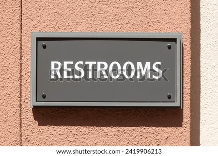 Restrooms sign with braille characters for the visually impaired and blind people.