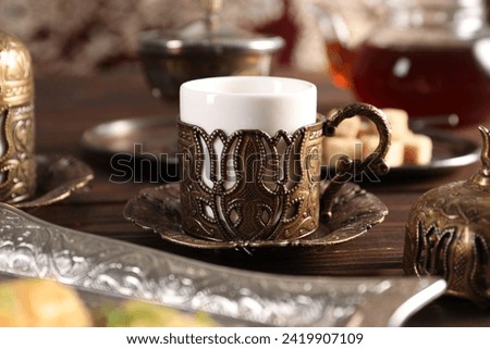 Traditional Turkish tea served in vintage tea set on wooden table, closeup