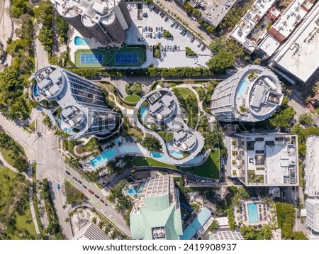 Aerial overhead photo of a building with rooftop swimming pool and palms