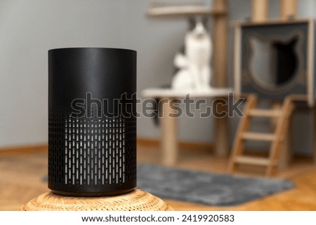 air purifier in the area with pets or cat. Air Pollution Concept. Air purifier, filters out invisible viruses, allergens or pollutants in the house on a cat tree background. Cute cat and Air purifier Royalty-Free Stock Photo #2419920583