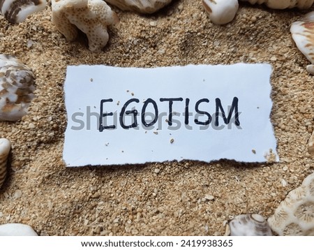Egotism writting on beach sand background.