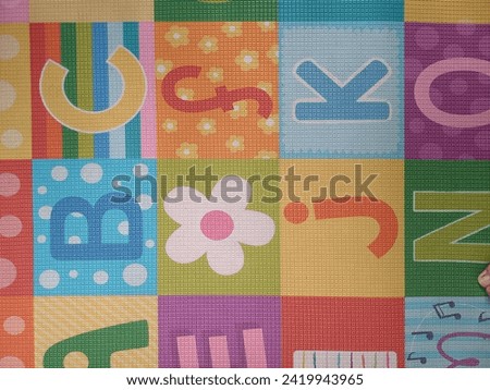 Photo from above, a colorful mattress model for children with cute letter motifs.