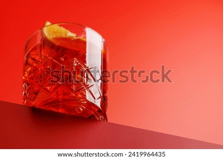 Cocktail delight: Classic negroni against a red background with copy space