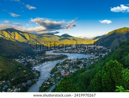 This is a scenic view of Srinagar city in Uttarakhand, India, surrounded by mountains. The city was the old capital of the Panwar kings of Garhwal. The Alaknanda River flows through the city. Royalty-Free Stock Photo #2419970267