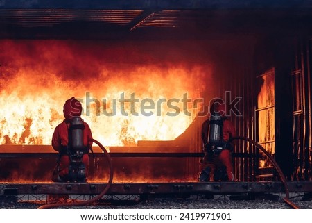 Firefighter Concept. Several firefighters go offensive for a fire attack. Fireman using water and extinguisher to fighting with fire flame. 