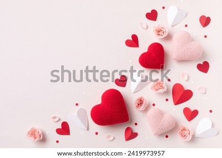 Valentine day or Mother day background decorated with pink red hearts and roses flowers top view. Flat lay festive greeting card.
