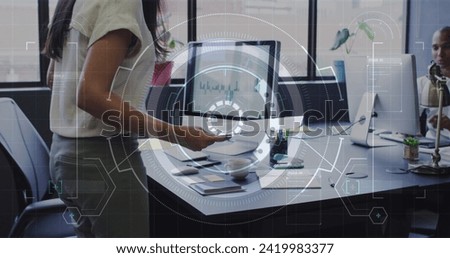 Image of data processing over biracial businesswoman working in office. Global business, finances, computing and data processing concept digitally generated image.