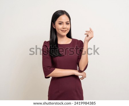 Attractive Young asian business woman smiling to camera standing pose on isolated white background. Latin Female around 25 in red dress portrait shot in studio. Royalty-Free Stock Photo #2419984385