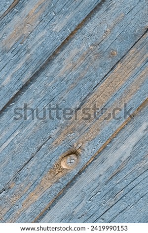 It is a close up view of an old blue painted wooden fence. It is view of weathered painted wood texture. It is photo of aged fence