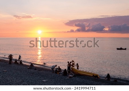 seashore at sunset, people in the distance