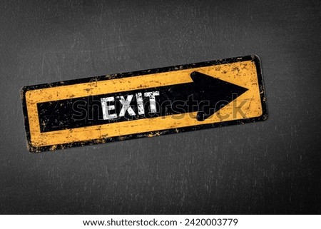 Exit. Direction arrow with text on a dark chalkboard background.