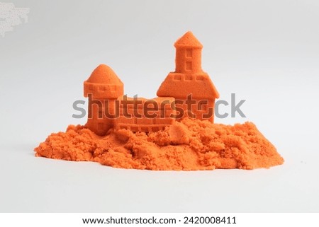 Castle figures made of orange kinetic sand isolated on white Royalty-Free Stock Photo #2420008411