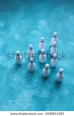 Group of white bowling pins on a blue background. Selective focus.