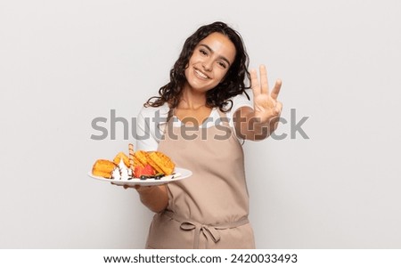 young hispanic woman smiling and looking friendly, showing number three or third with hand forward, counting down