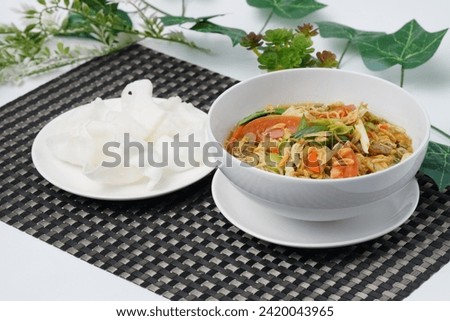 bowl of "mie godog" or noodle soup with crakcers 
