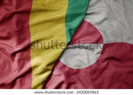 big waving national colorful flag of and national flag of guinea . macro