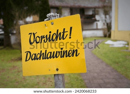  Sign with the German inscription Vorsicht Dachlawinen in front of a church in Inzell in Bavaria. Translation: Beware of roof avalanches                               