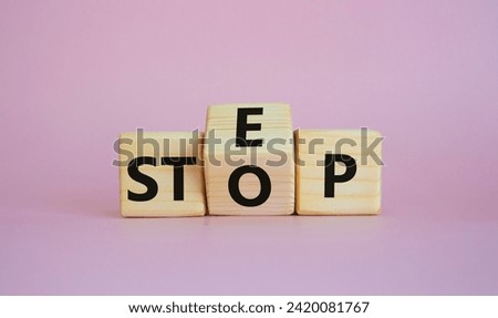 Step vs Stop symbol. Wooden cubes with words Stop and Step. Beautiful pink background. Step vs Stop and business concept. Copy space