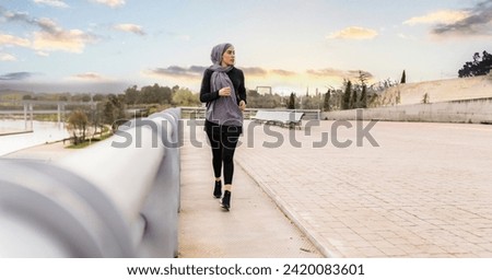 Veiled woman is running through the park outdoors 