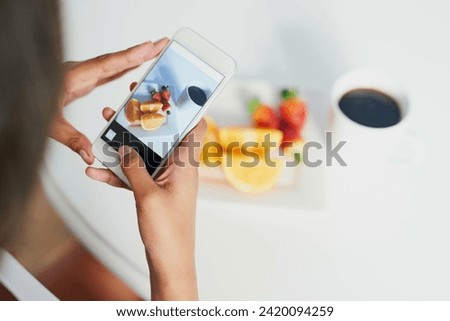 Looks good enough to eat. Shot of an unidentifiable woman taking a picture of her breakfast with her smartphone.