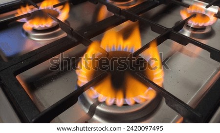 Red yellow flame of natural gas burns when there is a lack of oxygen. Danger of carbon monoxide poisoning in the kitchen gas stove hob closeup Royalty-Free Stock Photo #2420097495