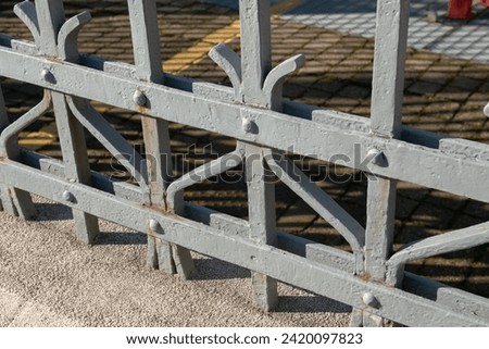 wrought iron railing, old factory gate with allegorical elements fixed with rivets, the painting prevents the rust that tends to create on these iron gates. Royalty-Free Stock Photo #2420097823