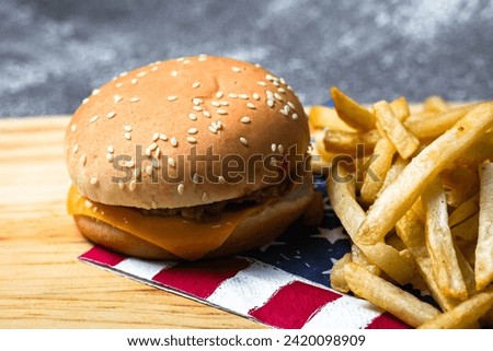 Burger and french fries on wooden board. American fast food.