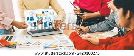 Cropped image of interior designer team presents color by using color swatches while laptop displayed UI and UX designs for mobiles app and website. Creative design and business concept. Variegated.