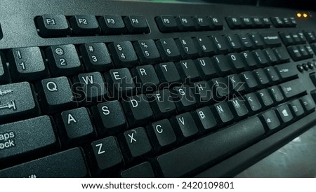 The photo depicts a black computer hardware device: a keyboard.