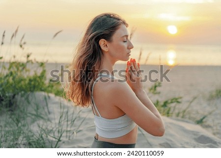 Woman practicing yoga at sunset on the beach, serene and peaceful. Royalty-Free Stock Photo #2420110059