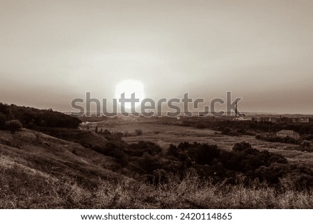 Sunset over city, view from a hill