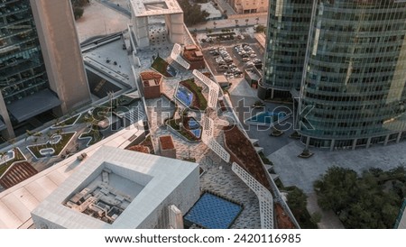 Dubai international financial center skyscrapers with promenade on a gate avenue aerial timelapse during all day. Futuristic mosque and walking area around with shadows moving fast Royalty-Free Stock Photo #2420116985