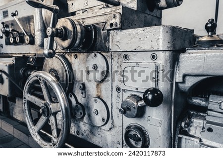 View of old lathe for metal processing in turning shop. Close-up photo of outdated equipment. Royalty-Free Stock Photo #2420117873