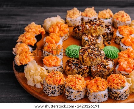 Tasty appetizing sushi rolls set on wooden board