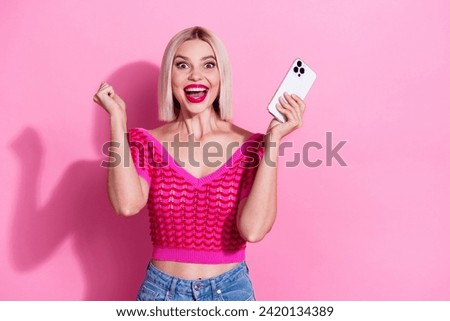 Photo of ecstatic funny woman with bob hairdo dressed knitwear clothes holding smartphone win bet screaming isolated on pink background