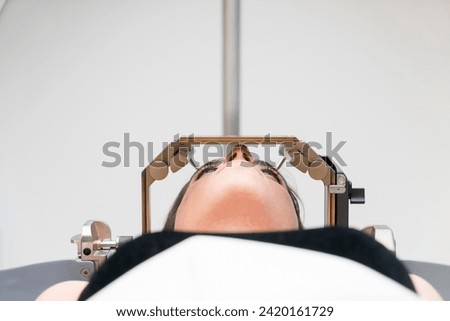 The patient lies in front of the device for the treatment of cancer with a gamma knife. She has a metal clip cap on his head. Gamma Knife stereotactic radiosurgery. Royalty-Free Stock Photo #2420161729