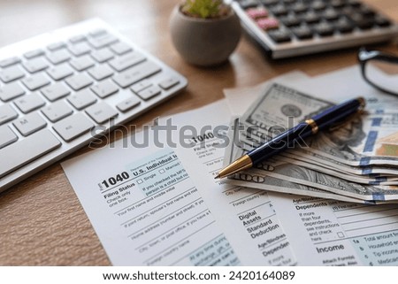 PC keyboard US dollar pen 1040 tax form on office table desktop. Tax time  concept