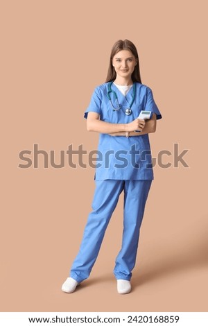 Beautiful doctor with infrared thermometer on beige background