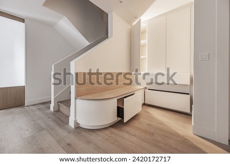 Home hall with custom-made furniture with open drawers and bench with semicircular edge Royalty-Free Stock Photo #2420172717