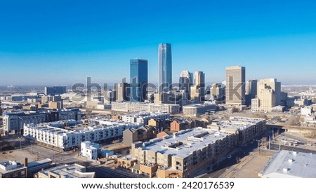 Aerial view downtown Oklahoma City with apartment complex, office buildings, skyscraper business district, residential high-rise condo, urban street under sunny clear blue sky winter time. USA