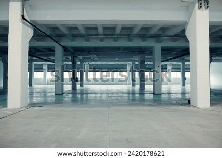 Industrial setting, empty warehouse with windows. Royalty-Free Stock Photo #2420178621