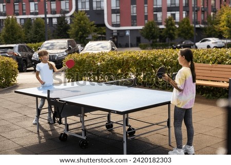 Little children playing ping pong in park