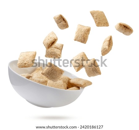 Cereal pillows fly off the plate close-up on a white background. Isolated Royalty-Free Stock Photo #2420186127