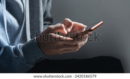 man's hand using mobile phone to type