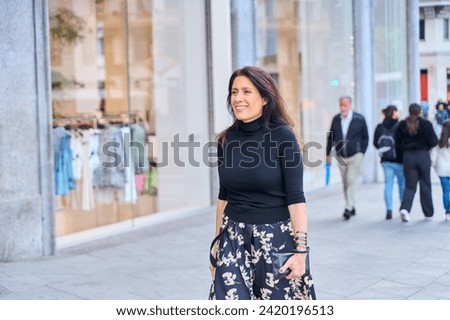 mature woman walking in the city, Caucasian brown woman dressed in elegant clothes